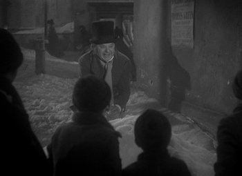 Movie still from “A Christmas Carol” (1938), directed by Edwin L. Marin – A man wearing a top hat and a tie; Medium shot, High angle