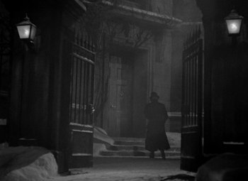 Movie still from “A Christmas Carol” (1938), directed by Edwin L. Marin – A man walking down a street in the snow; Wide shot, Low angle