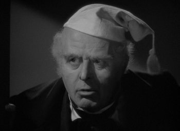 Movie still from “A Christmas Carol” (1938), directed by Edwin L. Marin – An older man wearing a white hat and a black suit; Close Up shot, High angle