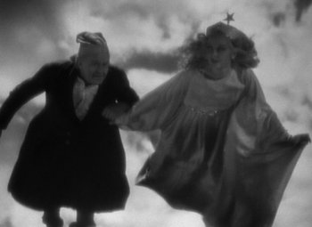 Movie still from “A Christmas Carol” (1938), directed by Edwin L. Marin – An old man and a young girl holding hands; Medium shot, Low angle