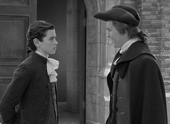 Movie still from “A Christmas Carol” (1938), directed by Edwin L. Marin – Two men in old - fashioned clothing talking to each other; Medium shot, Over the shoulder angle