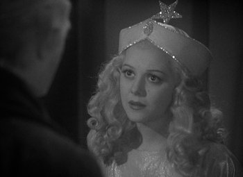 Movie still from “A Christmas Carol” (1938), directed by Edwin L. Marin – A young girl wearing a white dress with a star on it; Close Up shot, Over the shoulder angle