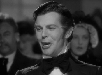 Movie still from “A Christmas Carol” (1938), directed by Edwin L. Marin – A black and white photo of a man wearing a bow tie; Close Up shot, Over the shoulder angle