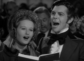 Movie still from “A Christmas Carol” (1938), directed by Edwin L. Marin – A man and a woman singing in a choir; Medium shot, Low angle