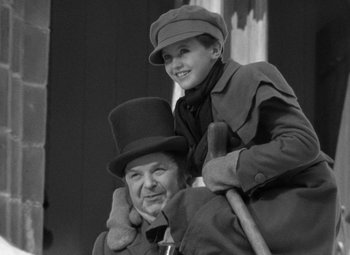 Movie still from “A Christmas Carol” (1938), directed by Edwin L. Marin – A man and a boy are sitting on top of each other; Medium shot, Low angle