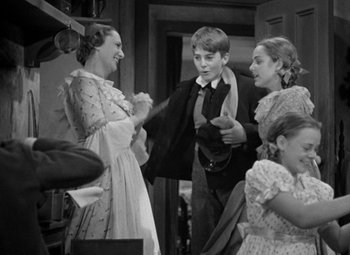 Movie still from “A Christmas Carol” (1938), directed by Edwin L. Marin – A group of people standing in a room; Medium shot, Over the shoulder angle