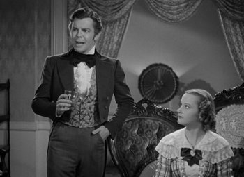 Movie still from “A Christmas Carol” (1938), directed by Edwin L. Marin – A man and a woman standing next to each other in a room; Medium shot, Over the shoulder angle