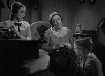 Movie still from “A Christmas Carol” (1938), directed by Edwin L. Marin – Two women and a girl sitting in a room; Medium shot, High angle