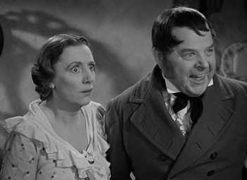 Movie still from “A Christmas Carol” (1938), directed by Edwin L. Marin – An old photo of a man and a woman; Medium shot, Over the shoulder angle