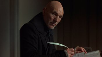 Movie still from “A Christmas Carol” (1999), directed by David Hugh Jones – A bald man in a black coat holding a knife; Close Up shot, Low angle