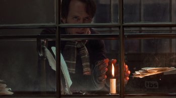 Movie still from “A Christmas Carol” (1999), directed by David Hugh Jones – A man holding a candle in front of a window; Close Up shot, Over the shoulder angle