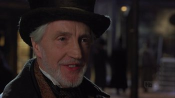 Movie still from “A Christmas Carol” (1999), directed by David Hugh Jones – An older man wearing a top hat and a suit; Close Up shot, Low angle