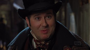 Movie still from “A Christmas Carol” (1999), directed by David Hugh Jones – A person wearing a top hat; Close Up shot, Over the shoulder angle