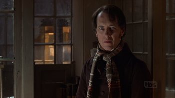 Movie still from “A Christmas Carol” (1999), directed by David Hugh Jones – A man wearing a coat and a striped scarf; Close Up shot, Over the shoulder angle