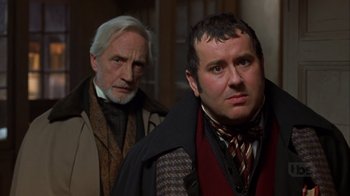 Movie still from “A Christmas Carol” (1999), directed by David Hugh Jones – Two men standing next to each other in front of a building; Close Up shot, Over the shoulder angle