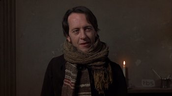 Movie still from “A Christmas Carol” (1999), directed by David Hugh Jones – A man wearing a scarf standing in front of a candle; Close Up shot, Low angle