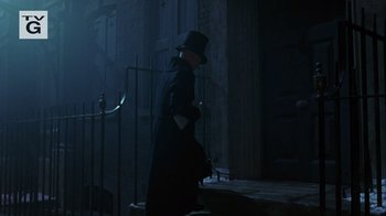 Movie still from “A Christmas Carol” (1999), directed by David Hugh Jones – A man in a long black coat and a black top hat; Wide shot, Low angle