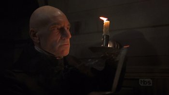 Movie still from “A Christmas Carol” (1999), directed by David Hugh Jones – A bald man sitting in front of a laptop computer; Close Up shot, Low angle