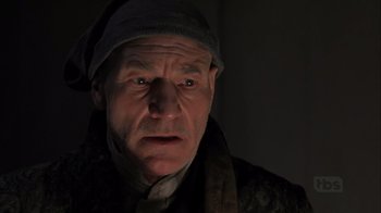 Movie still from “A Christmas Carol” (1999), directed by David Hugh Jones – An old man with a hat on looking at the camera; Close Up shot, Low angle