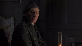 Movie still from “A Christmas Carol” (1999), directed by David Hugh Jones – A man sitting in front of a lit candle; Close Up shot, Over the shoulder angle