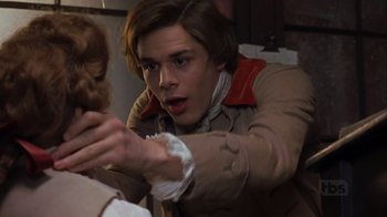 Movie still from “A Christmas Carol” (1999), directed by David Hugh Jones – A man in a trench coat holding a woman in a red jacket; Close Up shot, Over the shoulder angle