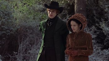 Movie still from “A Christmas Carol” (1999), directed by David Hugh Jones – A man and a woman dressed in period clothing walk through the woods; Medium shot, Low angle