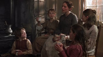Movie still from “A Christmas Carol” (1999), directed by David Hugh Jones – A group of people sitting in a living room; Medium shot, Over the shoulder angle