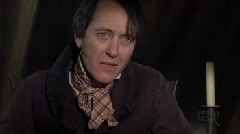 Movie still from “A Christmas Carol” (1999), directed by David Hugh Jones – A person wearing a jacket and tie; Close Up shot, Low angle
