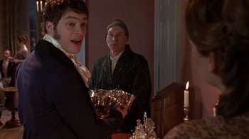 Movie still from “A Christmas Carol” (1999), directed by David Hugh Jones – Two people in a room holding a silver tray; Medium shot, Over the shoulder angle
