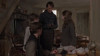 Movie still from “A Christmas Carol” (1999), directed by David Hugh Jones – A group of people standing around a table; Medium shot, Low angle