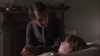 Movie still from “A Christmas Carol” (1999), directed by David Hugh Jones – A man and a child in a room with a fire place in the background; Medium shot, Over the shoulder angle