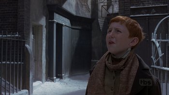 Movie still from “A Christmas Carol” (1999), directed by David Hugh Jones – A young boy standing in the middle of an alleyway; Medium shot, Low angle
