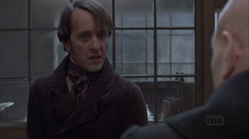 Movie still from “A Christmas Carol” (1999), directed by David Hugh Jones – A man in a brown coat and a red scarf; Close Up shot, Over the shoulder angle