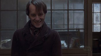 Movie still from “A Christmas Carol” (1999), directed by David Hugh Jones – A man smiling in front of a window; Close Up shot, Low angle