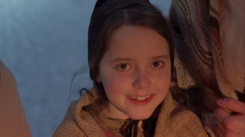 Movie still from “A Christmas Carol” (1999), directed by David Hugh Jones – A young girl smiling for the camera; Close Up shot, High angle