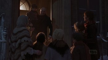 Movie still from “A Christmas Carol” (1999), directed by David Hugh Jones – A group of people standing around a building; Medium shot, Low angle