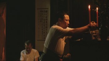 Movie still from “A City of Sadness” (1989), directed by Hsiao-Hsien Hou – A man in a white shirt is standing in front of another man in a white shirt; Medium shot, Low angle