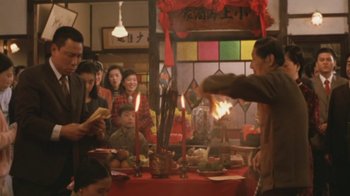 Movie still from “A City of Sadness” (1989), directed by Hsiao-Hsien Hou – A group of people sitting around a table with candles on it; Medium shot, Over the shoulder angle