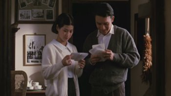 Movie still from “A City of Sadness” (1989), directed by Hsiao-Hsien Hou – A man and a woman looking at papers in a room; Medium shot, High angle