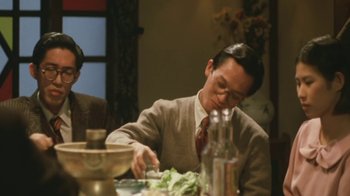 Movie still from “A City of Sadness” (1989), directed by Hsiao-Hsien Hou – A man sitting at a table with a bowl of salad; Medium shot, Low angle