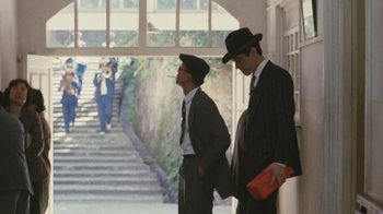 Movie still from “A City of Sadness” (1989), directed by Hsiao-Hsien Hou – A couple of men standing next to each other on some stairs; Wide shot, Low angle