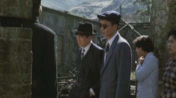 Movie still from “A City of Sadness” (1989), directed by Hsiao-Hsien Hou – A group of men standing next to each other in suits; Medium shot, Over the shoulder angle