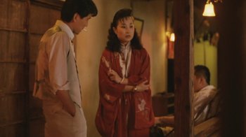 Movie still from “A City of Sadness” (1989), directed by Hsiao-Hsien Hou – A woman in a red robe standing next to a man in a white shirt; Medium shot, Over the shoulder angle