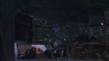 Movie still from “A City of Sadness” (1989), directed by Hsiao-Hsien Hou – A group of people standing in the street at night; Extreme Wide shot, High angle