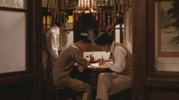 Movie still from “A City of Sadness” (1989), directed by Hsiao-Hsien Hou – A group of men sitting at a table in a room; Wide shot, High angle