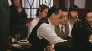 Movie still from “A City of Sadness” (1989), directed by Hsiao-Hsien Hou – A group of people sitting around a table; Medium shot, Over the shoulder angle