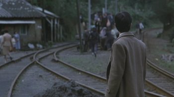 Movie still from “A City of Sadness” (1989), directed by Hsiao-Hsien Hou – A man standing on the side of a train track; Wide shot, High angle