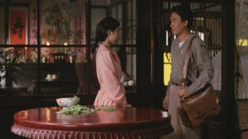 Movie still from “A City of Sadness” (1989), directed by Hsiao-Hsien Hou – A man and a woman standing next to each other in front of a table; Medium shot, Over the shoulder angle
