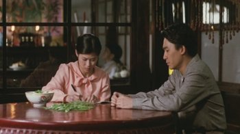 Movie still from “A City of Sadness” (1989), directed by Hsiao-Hsien Hou – A man and a woman sitting at a wooden table; Medium shot, High angle
