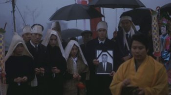 Movie still from “A City of Sadness” (1989), directed by Hsiao-Hsien Hou – A group of people standing under an umbrella; Medium shot, High angle